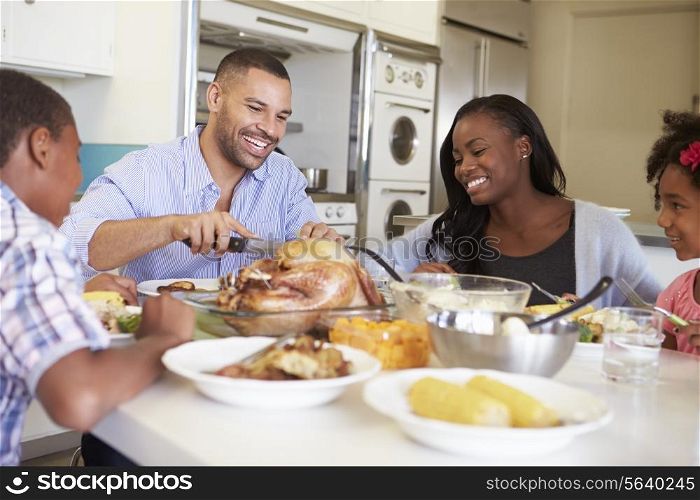 Family Sitting Around Table At Home Eating Meal