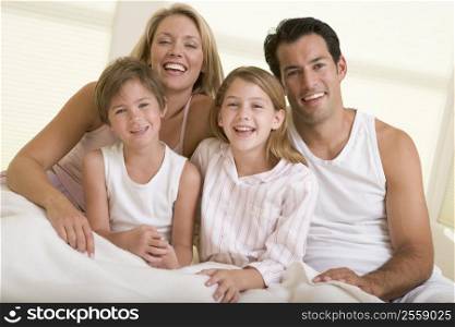 Family sitting in bed smiling