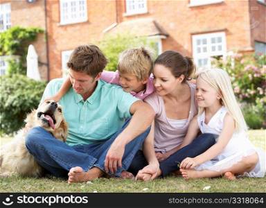 Family Sitting In Garden Together
