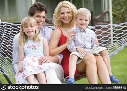 Family sitting in hammock smiling