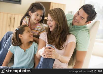 Family sitting in living room smiling