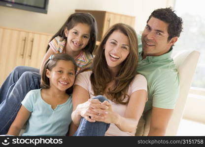 Family sitting in living room smiling