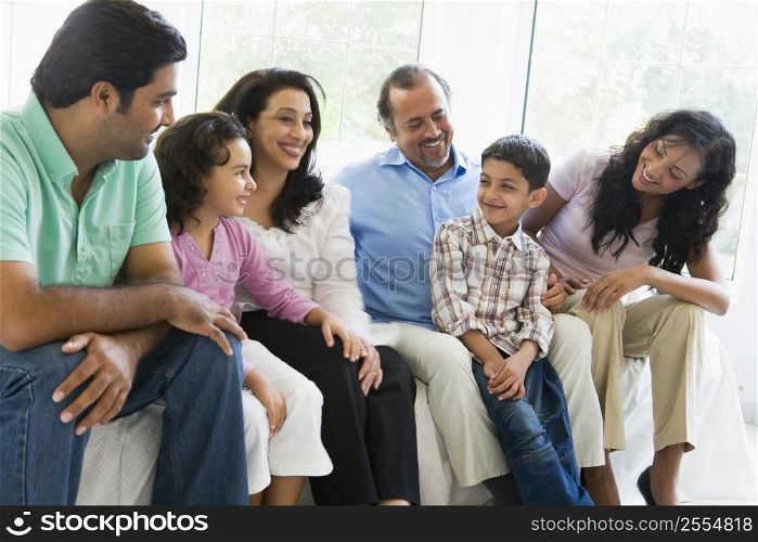 Family sitting in living room smiling (high key)