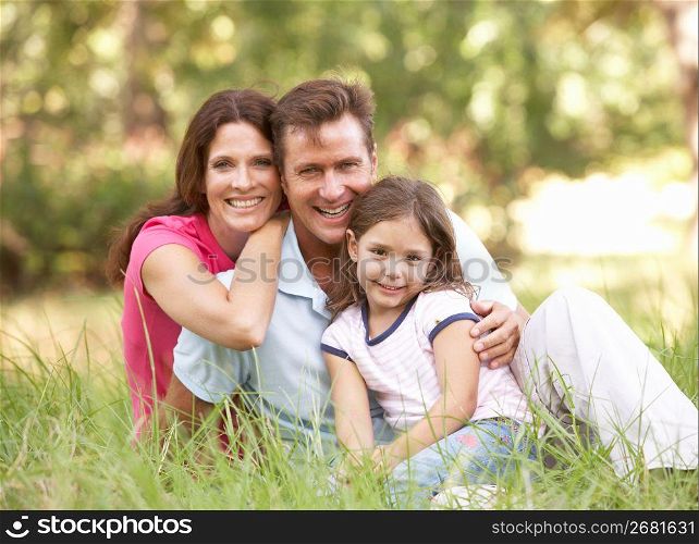 Family Sitting In Long Grass In Park