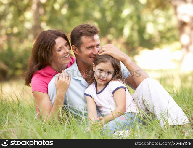 Family Sitting In Long Grass In Park