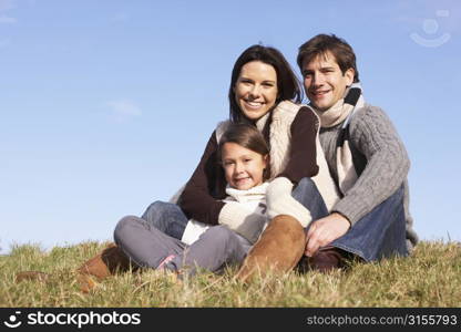 Family Sitting In Park