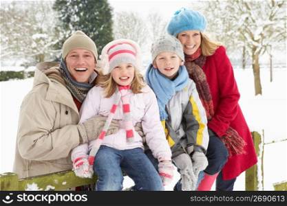 Family Sitting In Snowy Landscape