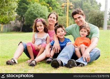 Family sitting in the summer park and enjoying sunny day
