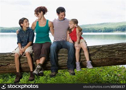 Family sitting on a log