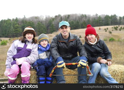 Family sitting on a vagon on Christmas tree farm