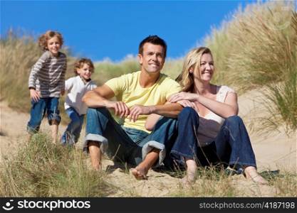 Family Sitting on Beach Having Fun