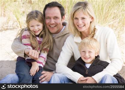 Family sitting on beach smiling