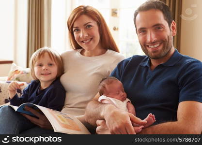 Family Sitting On Sofa With Newborn Baby