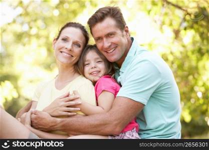 Family Sitting On Tree In Park