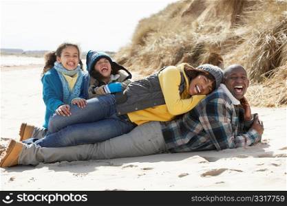 Family Sitting On Winter Beach