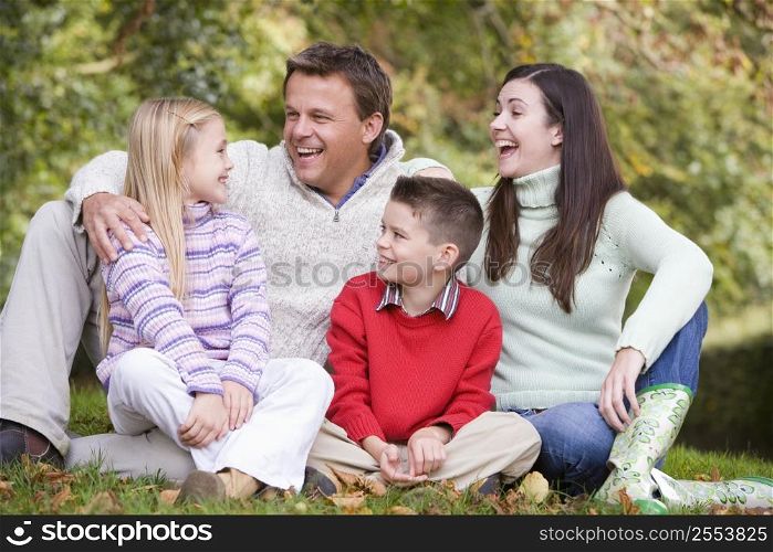 Family sitting outdoors laughing (selective focus)