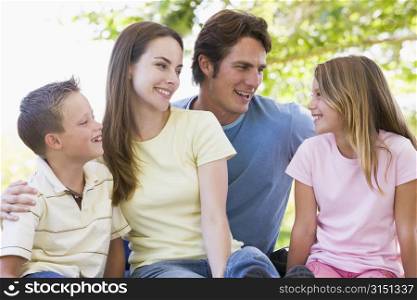 Family sitting outdoors smiling