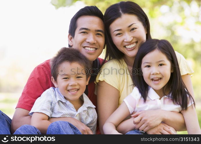 Family sitting outdoors smiling