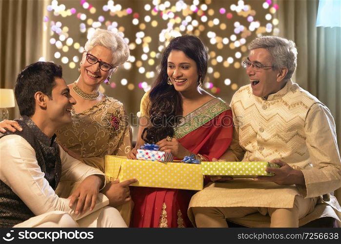 Family sitting together and laughing with gifts on the occasion of diwali