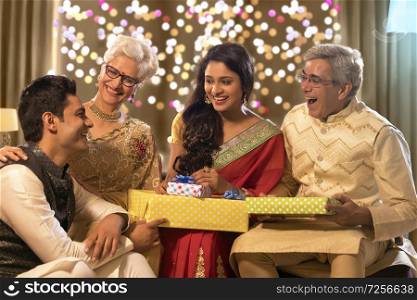 Family sitting together and laughing with gifts on the occasion of diwali