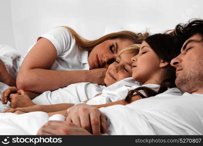 Family sleeping together. Family with two children sleeping together on a same bed