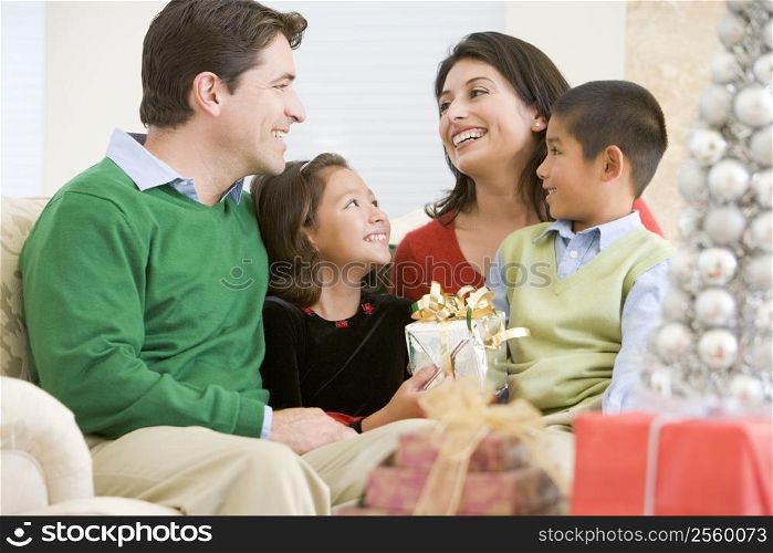 Family Smiling At Each Other,Holding Christmas Gift