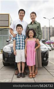 Family smiling in front of the car, portrait