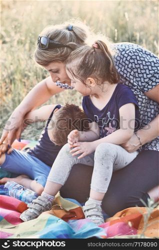 Family spending time together on a meadow, close to nature. Parents and children playing together. Candid people, real moments, authentic situations