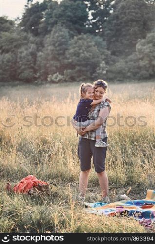 Family spending time together on a meadow, close to nature, parents and children playing together. Candid people, real moments, authentic situations