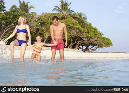 Family Splashing In The Sea On Tropical Beach Holiday