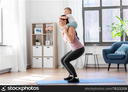 family, sport and motherhood concept - happy smiling mother with little baby exercising at home. happy mother with little baby exercising at home