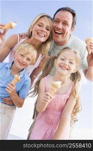 Family standing at beach with ice cream smiling