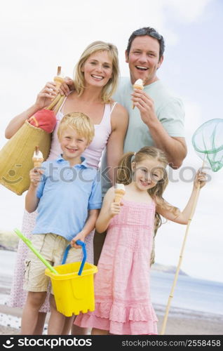 Family standing at beach with ice cream smiling