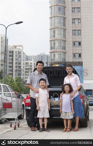 Family standing next to the car with shopping bags