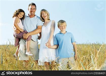 Family standing outdoors holding hands smiling
