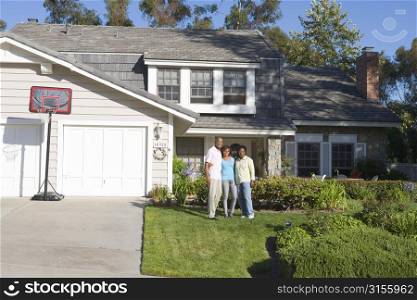 Family Standing Outside House