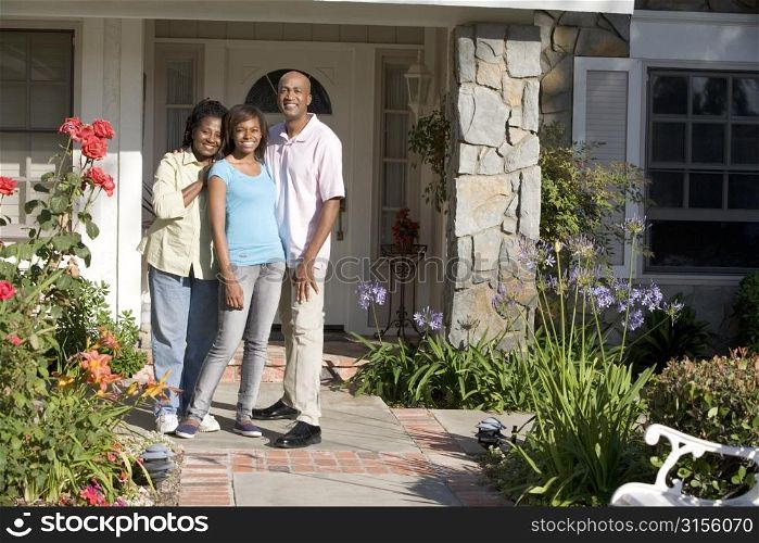 Family Standing Outside House