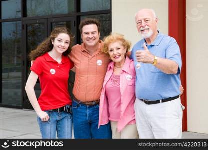 Family standing outside their polling place wearing I Voted stickers. (stickers are generic ones, not trademarked)