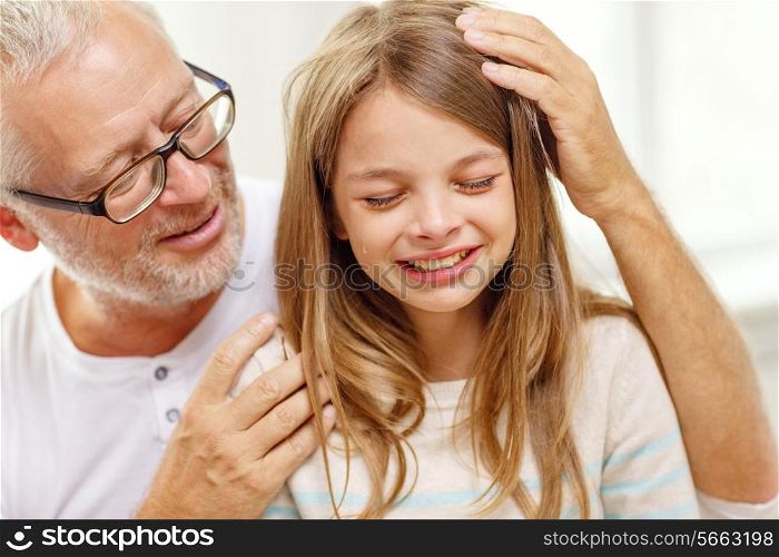 family, support, childhood and people concept - grandfather with crying granddaughter at home