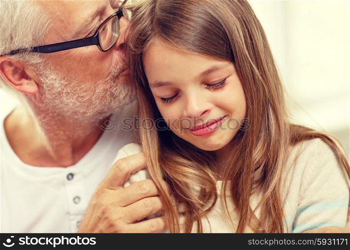 family, support, childhood and people concept - grandfather with crying granddaughter at home
