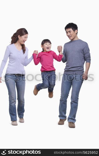 Family swinging child in mid-air, studio shot