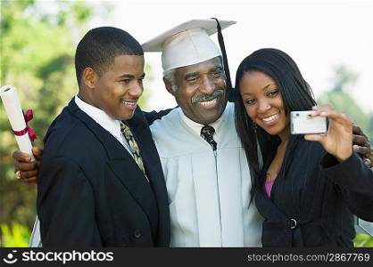 Family Taking Picture at Graduation with Cell Phone