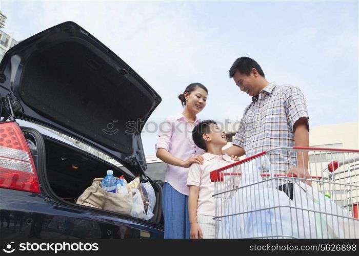 Family talking next to the car with shopping bags