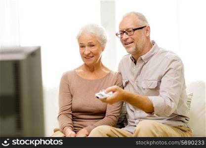 family, technology, age and people concept - happy senior couple watching tv at home