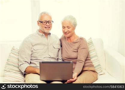 family, technology, age and people concept - happy senior couple with laptop computer at home