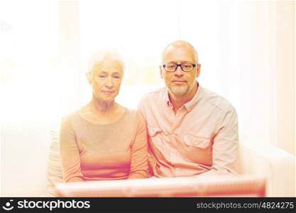 family, technology, age and people concept - senior couple watching tv at home