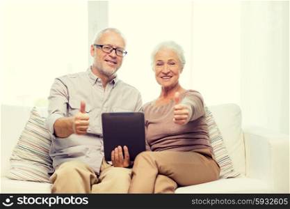 family, technology, age, gesture and people concept - happy senior couple with tablet pc computer showing thumbs up at home