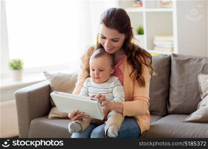 family, technology and motherhood concept - happy smiling young mother with little baby and tablet pc computer at home. happy mother with baby and tablet pc at home