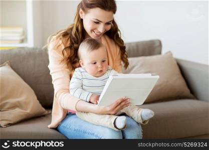 family, technology and motherhood concept - happy smiling young mother with little baby and tablet pc computer at home. happy mother with baby and tablet pc at home