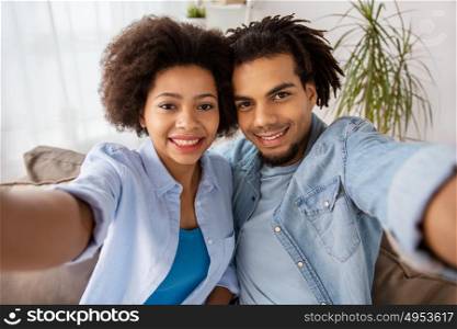 family, technology and people concept - happy couple taking selfie at home. happy couple taking selfie at home